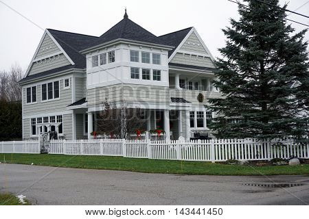 WEQUETONSING, MICHIGAN / UNITED STATES - DECEMBER 22, 2015: A large home with a white picket fence on Pennsylvania Avenue in Wequetonsing.
