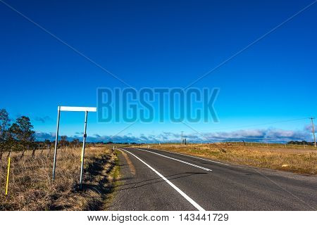 Australian outback road with road sign. Rural road on sunny day. Young region NSW Australia