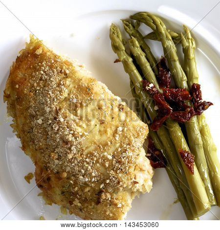 Salmon and whitebait quiche with asparagus and dried tomato on a dish.