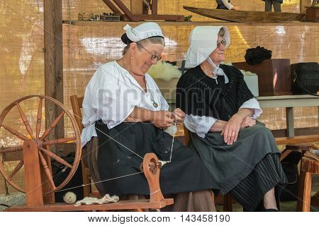 Woman Using An Antique Spinning Machine To The Wire