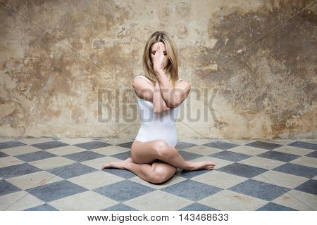 Young woman in yoga pose sitting on the floor