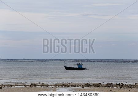 Small fishing boats in seaside of Coast on time low tide and sky background.