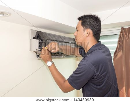 Single electrician man clean fix and maintain air conditioning in the house