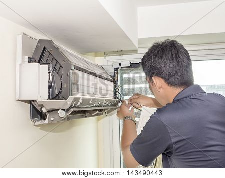 Single electrician man clean fix and maintain air conditioning in the house
