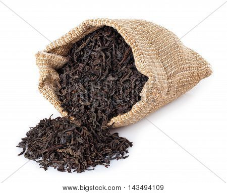 Black tea scattered of burlap bag isolated on white background. Black tea. Dry leaves of tea scattered of sack isolated on white. Scattered leaves of tea