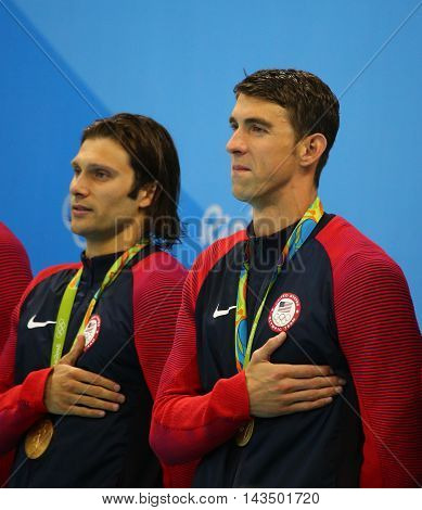 RIO DE JANEIRO, BRAZIL - AUGUST 13, 2016: USA Men's 4x100m medley relay team  Cory Miller (L) and  Michael Phelps celebrate victory at the Rio 2016 Olympic Games at the Olympic Aquatics Stadium
