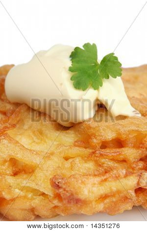 Bramborák (latke) v detailním záběru, s kopečkem kysané smetany.