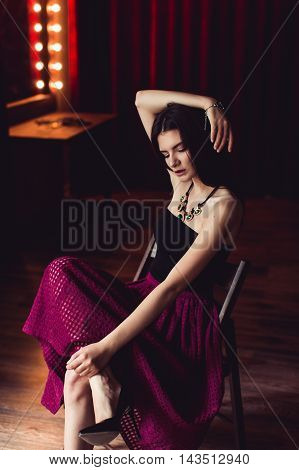 young brunette model posing in fashionable clothes in burlesque fitting room