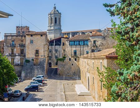 Girona Spain - July 30 2016. Les Aligues building University of Gerona in Placa de Sant Domenec square with bell tower of Santa Maria cathedral in background. Gerona Costa Brava Catalonia Spain.