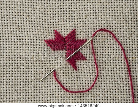 Fragment of embroidery on the canvas with a needle