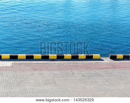 Textured Background Of Sea Water And A Pier In The City Seaport