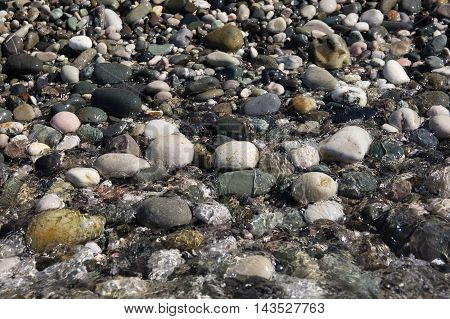ocks visible through the water and waves