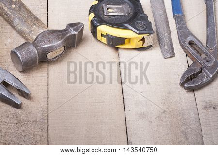 Construction tools on wooden background. Copy space for text. Set of assorted work tools at wood table . Top view.