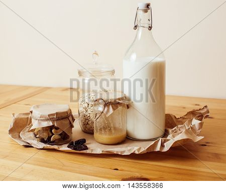 real comfort wooden kitchen with breakfast ingredients close up in glass, honey, oatmeal, milk, muesli, morning food