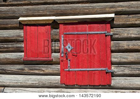 Red old door and window on the wooden wall of a village house. Excellent background
