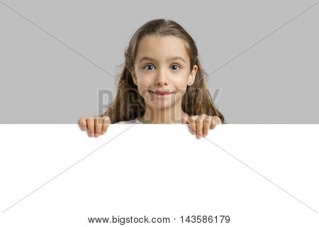 Cute little girl holding a blankboard, with copy space