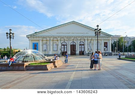 MOSCOW RUSSIA - JULY 23 2016: Unidentified people walk on Manezhnaya Square near Central Exhibition Hall Manege Moscow Russia
