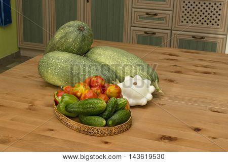 zucchini squash tomatoes and cucumbers on the table in the kitchen in the countryside