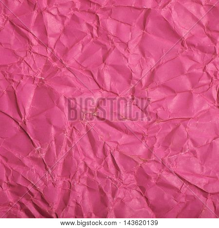 Close-up fragment of a pink magenta crumpled paper texture as a backdrop composition
