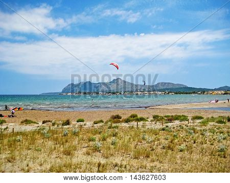 Pollenca Majorca Spain - June 28 2008: Kite surfers at bay of Pollenca - somewhere between Pollenca and Alcudia view towards peninsula Victoria north of Majorca - natural beach in front