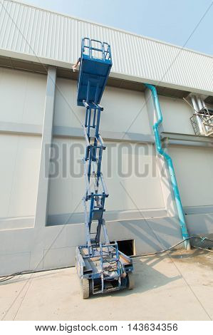 Builder on a Scissor Lift Platform at a construction site. Men at work