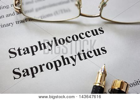 Paper with words staphylococcus saprophyticus  and glasses. Medical concept.