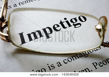 Paper with word Impetigo and glasses. Medical concept.