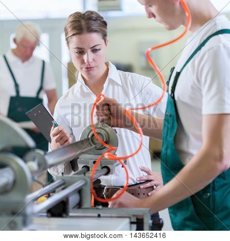 Manager controlling employees during work in production centre