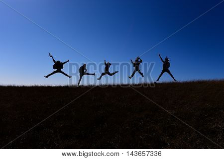 They are jumping while walking on a hill of Doi Mon jong the mountain in Chiang Mai, Thailand.