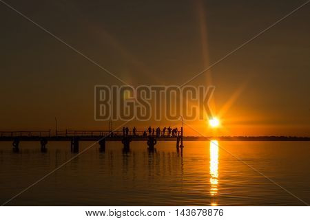 Summer sunset at the pier. Evening fishing