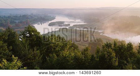 Summer landscape with the beautiful river and morning fog. Deciduous forest on a hill. Ros river, Ukraine, Europe