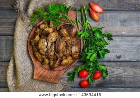 Stewed chicken liver additional ingredients for chicken liver parsley dill cherry tomatoes shallot gray wooden background rustic style top view