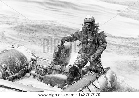 SOUTH GEORGIA, GREAT BRITAIN - NOV 9, 2012: Unidentified man in a water proof suite in a rubber boat with a motor in the Atlantic Ocean. Atlantic Ocean is the world's second largest ocean
