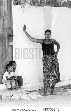 KARA, TOGO - MAR 9, 2013: Unidentified Togolese children sit near a house door. Children in Togo suffer of poverty due to the unstable econimic situation