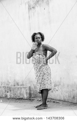 KARA, TOGO - MAR 9, 2013: Unidentified Togolese woman stays near a house. People in Togo suffer of poverty due to the unstable econimic situation