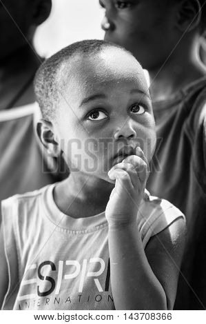 KARA, TOGO - MAR 9, 2013: Unidentified Togolese boy thinks of something. Children in Togo suffer of poverty due to the unstable econimic situation