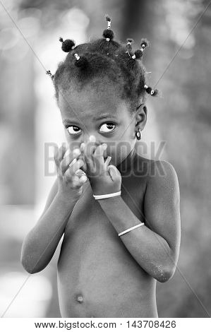 KARA, TOGO - MAR 9, 2013: Unidentified Togolese cute little girl in the street. Children in Togo suffer of poverty due to the unstable econimic situation