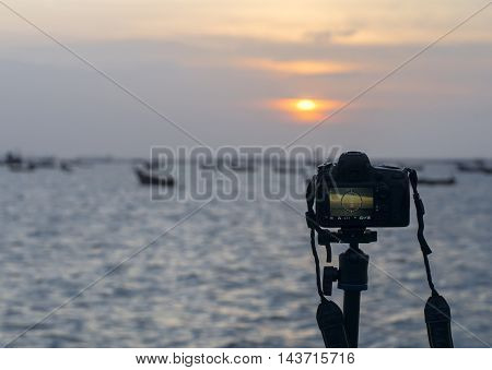 Closeup of a camera on a tripod outdoors. Background Landscape out of focus