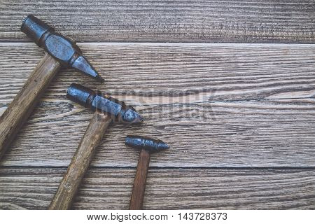 Set of old and rusty hammers on wooden background