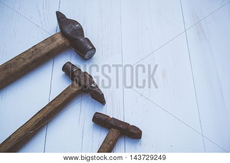 Set of old and rusty hammers on blue background