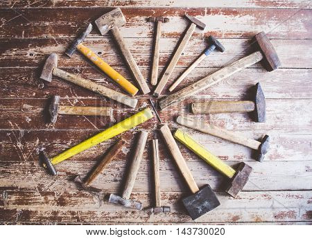 Set of old and rusty hammers on wooden background