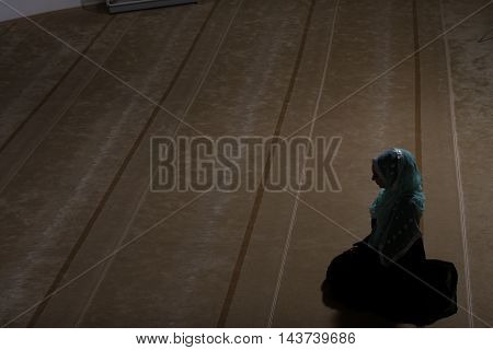Young Muslim Woman Making Traditional Prayer To God While Wearing A Traditional Hijab And Dress