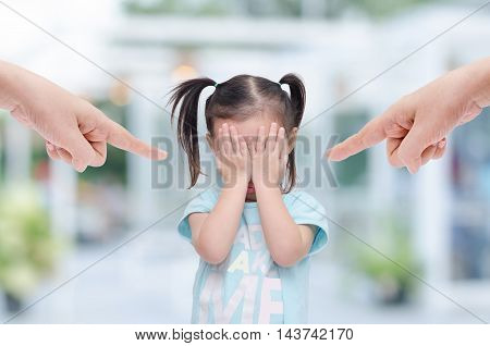 Little asian girl crying while parents scold her