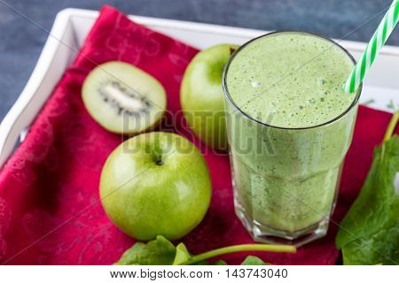 green smoothie with spinach kiw iand apple on a tray selective focus