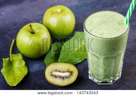 green smoothie with spinach kiw iand apple on a dark background selective focus