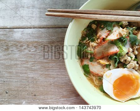 Noodle soup with boiled egg on a wooden table.