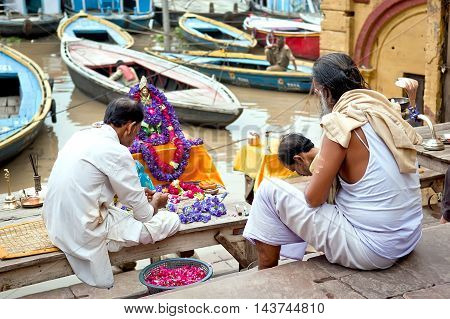 Varanasi Uttar Pradesh India - July 30, 2011: Unidentified Hindu pilgrims preparing for the Ganga Aarti ritual. Puja is a Hindu ritual that takes place at Triveni Ghat on the banks of the river Ganges