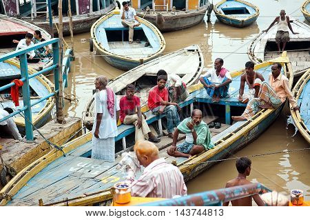 Varanasi Uttar Pradesh India - July 30, 2011: Boats and people at Triveni Ghat on the banks of the river Ganges in holy city of Varanasi.