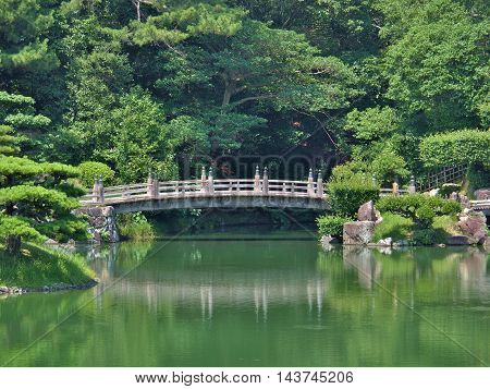 A wooden bridge in Ritsurin Garden in Takamatsu city, Kagawa Prefecture, Japan. Ritsurin Garden is one of the most famous historical gardens in Japan.