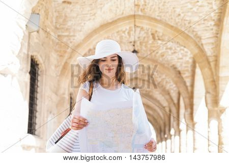 Teenage girl with a map on a city tour. Young and beautiful woman have a weekend in Larnaca. Vacation, holidays and traveling concept.